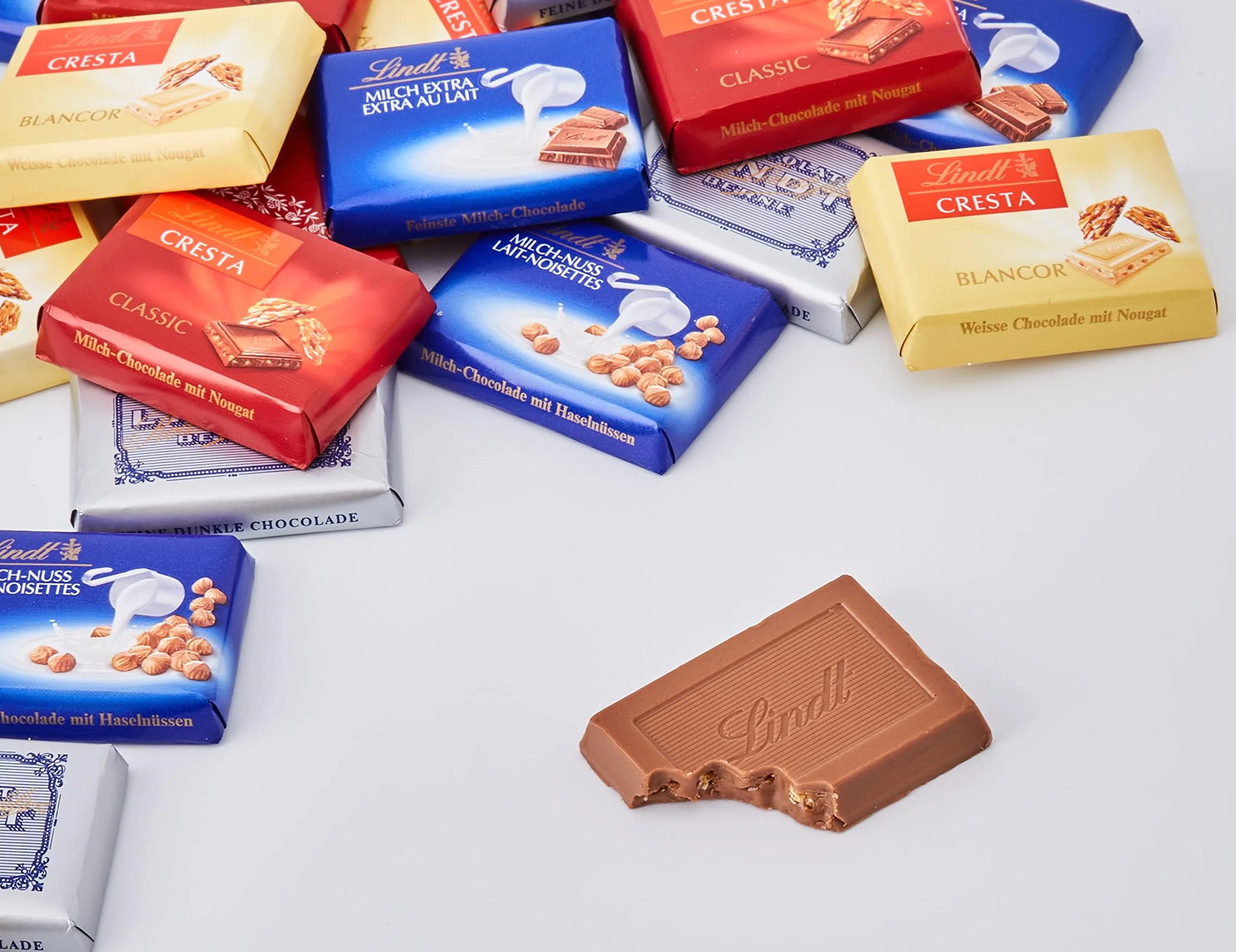 LINDT Napolitanas Suizas, contiene un surtido de minitabletas de chocolate envueltas individualmente, chocolate con leche, de chocolate blanco,chocolate negro,chocolate con avellanas, aprox76uds, 500g